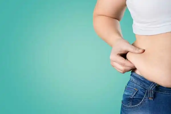 Image of woman pinching her love handles to show weight gain Rhyl