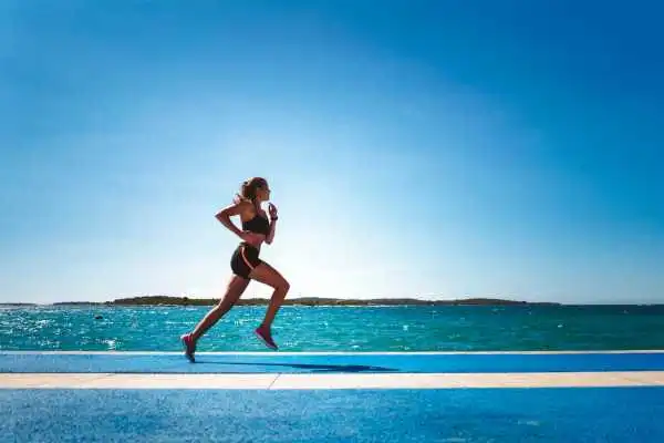 Woman running showing strong leg muscle Rhyl